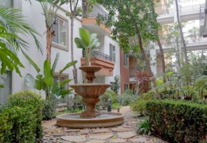Beautiful courtyard with tropical gardening and Italian-style fountain.