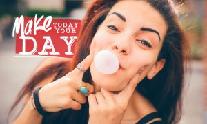 Make today your day: Young woman blowing a bubble and smiling.